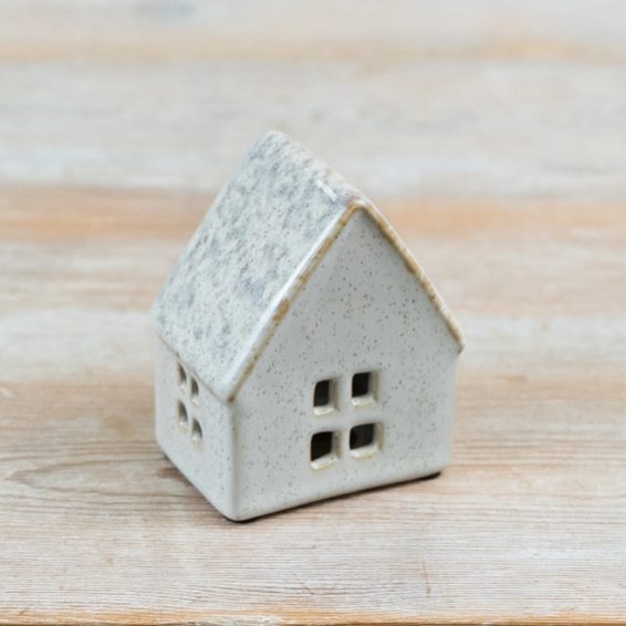 Small ceramic house tealight holder with a pitched roof and four cut-out front windows