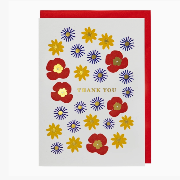 A square thank you card with a red envelope, featuring a white face decorated with red, yellow, and blue stylized flowers and the words 'THANK YOU' in gold at the center.