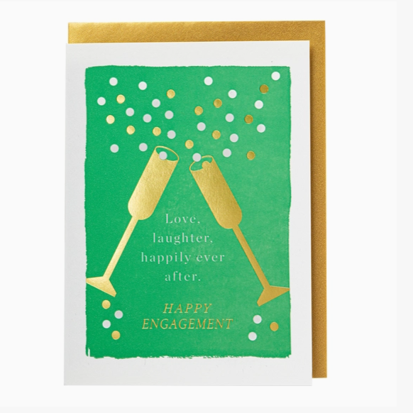 A square greeting card with a green front design featuring two gold champagne glasses, white and gold confetti dots, and the text 'Love, laughter, happily-ever after. HAPPY ENGAGEMENT.
