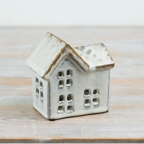 Multi-gabled ceramic house tealight holder showing cut-out windows on the front and side