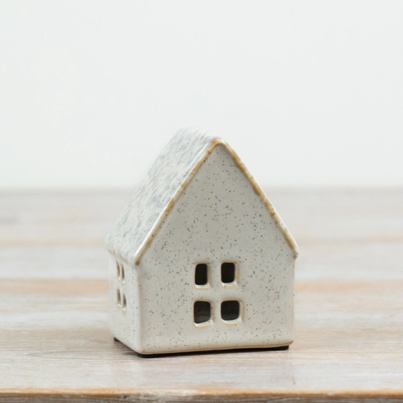 Small neutral ceramic house tealight holder with four square front windows, angled view