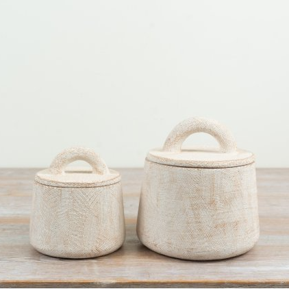 Small and large off-white cement storage pots with lidded tops and arched handles, styled side by side