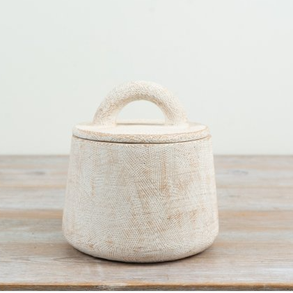 Off-white cement storage pot with a scored surface pattern and matching lid with an arched handle, shown straight on