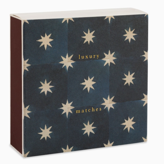 A rectangular box of luxury matches with a dark navy blue cover decorated with a grid of cream starburst motifs and gold text, shown against a plain white background.