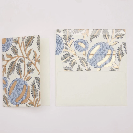 A matching stationery set featuring a folded card and an envelope with a botanical pattern in blue, beige, and brown on a white background.