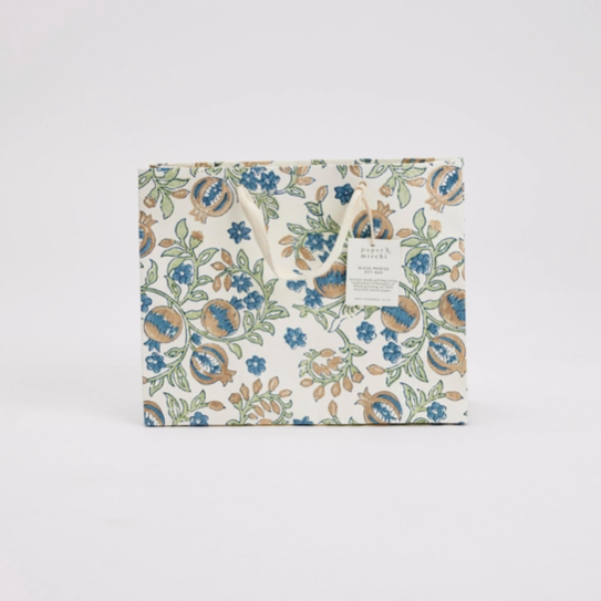 A square gift box with a vintage floral pattern in blue, green, and beige on an off-white background, featuring a small paper tag attached to the top.