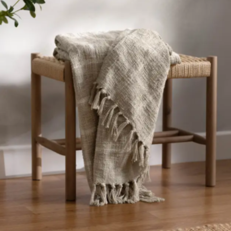 Beni Throw Blanket in beige plaid draped over a rustic wooden bench with tassel fringe detail — cosy autumn home decor by The Rustic Barn Company